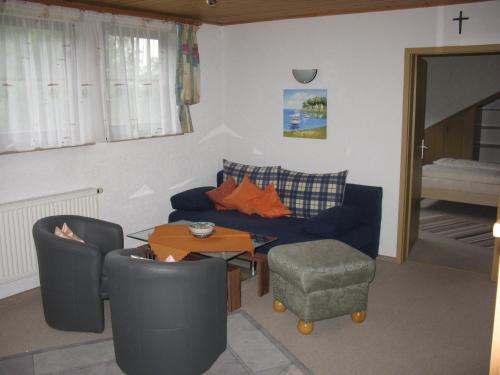 ヴァルメンシュタイナハにあるFerienwohnung Karlsruhのリビングルーム(青いソファ、テーブル付)