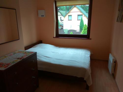 a small bedroom with a bed and a window at Zubrzyk in Łukęcin