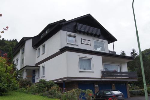 a white house with a dog in the window at Pension Schneider in Cochem