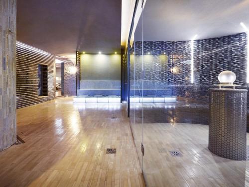 um quarto com uma parede de vidro e um piso de madeira em VacationClub - Olympic Park Apartment 404 em Kolobrzeg