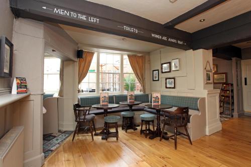 a restaurant with tables and chairs in a room at Original White Hart, Ringwood by Marston's Inns in Ringwood