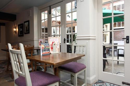 a dining room with a wooden table and chairs at Original White Hart, Ringwood by Marston's Inns in Ringwood