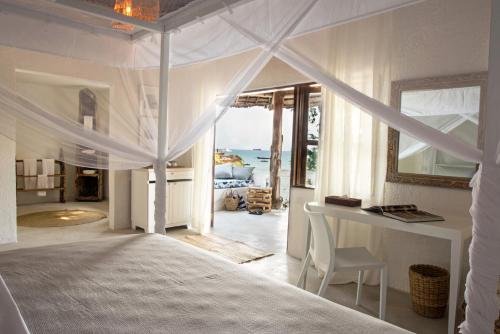 a bedroom with a bed with a view of the ocean at Chuini Zanzibar Lodge by NEWMARK in Zanzibar City