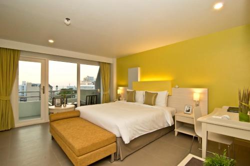 a bedroom with a large bed and a balcony at Sunshine Vista Hotel in Pattaya Central