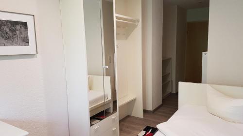 a white room with a bed and a mirror at Schneiderlein Hotel in Limbach - Oberfrohna