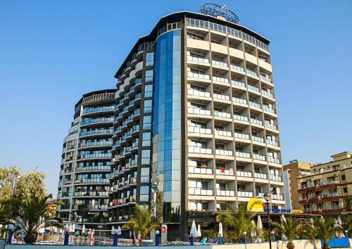 a tall building with a sign on top of it at Smartline Meridian Hotel in Sunny Beach