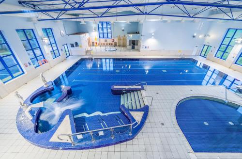 a large swimming pool in a building with a large at Breaffy House Hotel and Spa in Castlebar