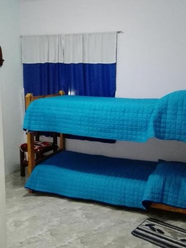 two bunk beds in a room with a window at Atardecer Serrano in Huerta Grande
