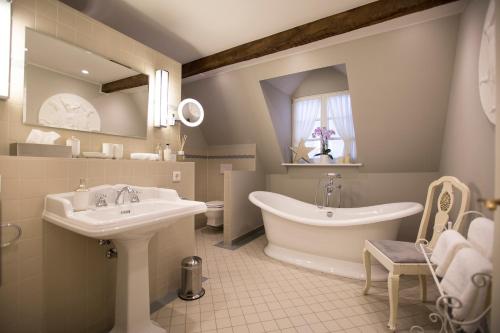 a bathroom with two sinks and a tub and a mirror at Romantik Hotel Zur Glocke in Trier