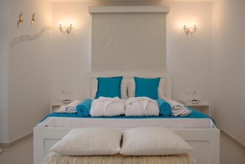 sypialnia z łóżkiem z niebiesko-białymi poduszkami w obiekcie Aristodimos Luxury Suite w mieście Kalamaki