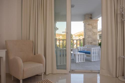 a living room with a chair and a balcony at Aristodimos Luxury Suite in Kalamaki Heraklion
