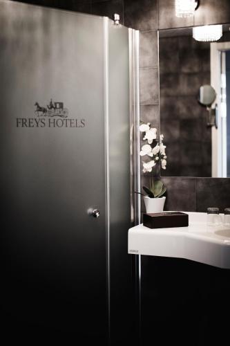 a bathroom with a shower with a sink and a mirror at Freys Hotel in Stockholm