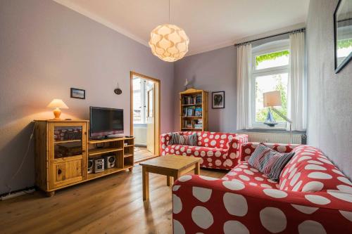 un soggiorno con due divani e una televisione di Ferienwohnungen Proll a Bansin