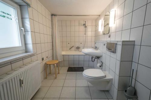 a white bathroom with a toilet and a sink at Ferienwohnungen Proll in Bansin