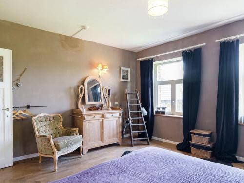 a bedroom with a mirror and a chair and a dresser at Bièvre Forest-Edge Retreat in Bellefontaine