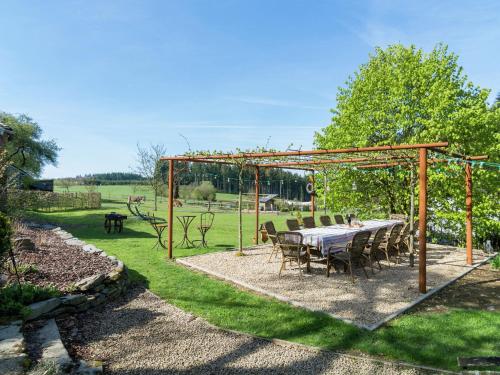 a table and chairs under a pergola in a yard at Bièvre Forest-Edge Retreat in Bellefontaine