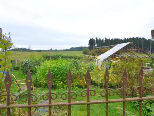 a fence in front of a garden with flowers at Bièvre Forest-Edge Retreat in Bellefontaine