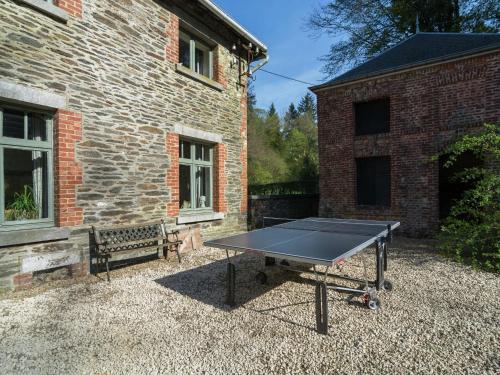 a ping pong table in front of a brick building at Bièvre Forest-Edge Retreat in Bellefontaine