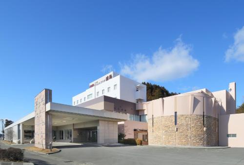 a hospital building with a blue sky in the background at Hotel Grand Plaza Urashima in Kurihara
