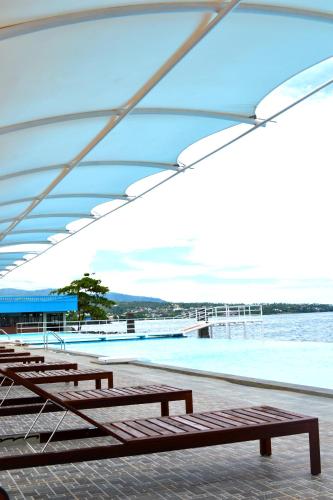 a group of benches sitting next to a body of water at Lion Hotel & Plaza Manado in Manado