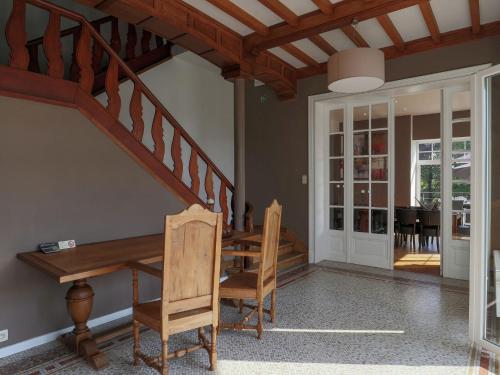 a dining room with a wooden table and stairs at Countryside Villa in Trois Ponts Liege with garden in Trois-Ponts