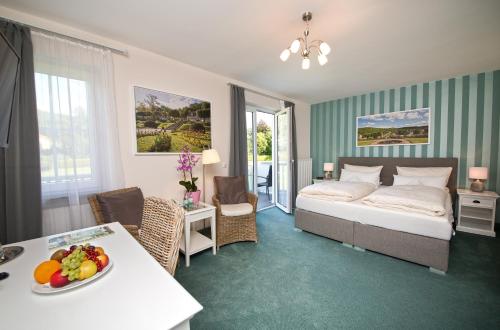 a hotel room with a bed and a table with a bowl of fruit on at Hotel Jägerhof in Staatsbad Brückenau