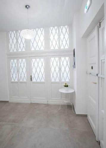 a large white room with a table and a large window at City Center Stúdió Apartmanok in Szeged