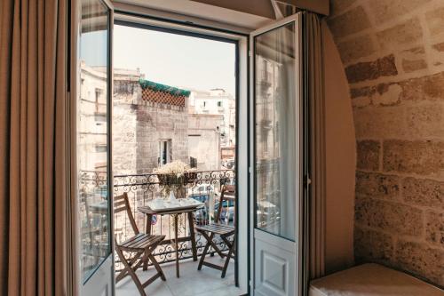 Habitación con balcón con mesa y sillas. en Hotel L'Arcangelo - Boutique Hotel, en Taranto