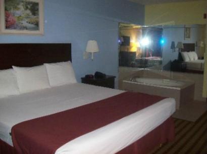 a hotel room with a bed and a bath tub at Fairway Inn La Porte in La Porte