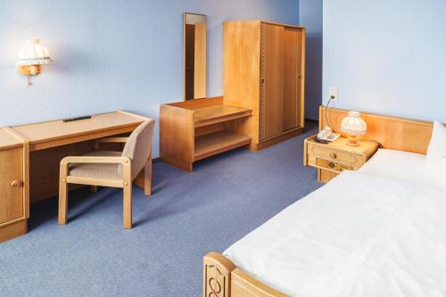 a hotel room with a bed and a desk and a desk at Hotel Hannover Airport by Premiere Classe in Hannover