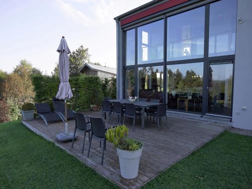a patio with a table and an umbrella at Wonderful Holiday Home in Ovifat with Sauna in Ovifat