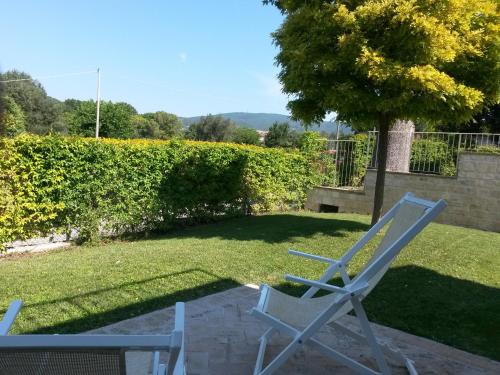 a white chair sitting in a yard next to a tree at Hotel Giardino Suites&Spa in Numana