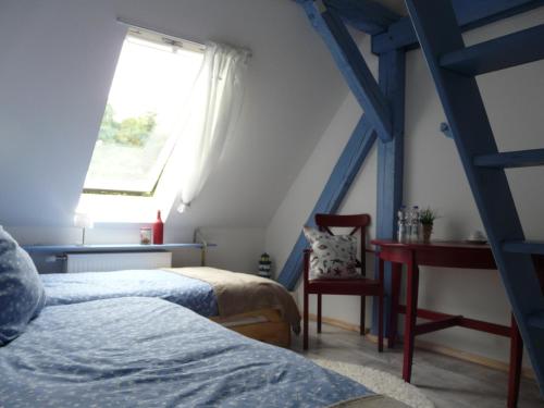 1 dormitorio con 2 camas, ventana y escalera en Zum Storchennest en Kemnitz