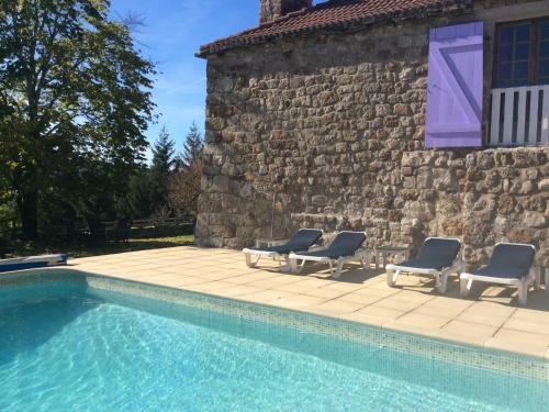 a swimming pool with four chairs and a building at Charming Farmhouse in Cros de G orand with Swimming Pool in Cros-de-Géorand