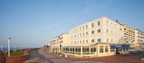 ein großes weißes Gebäude an der Straßenseite in der Unterkunft Strandhotel Georgshöhe in Norderney
