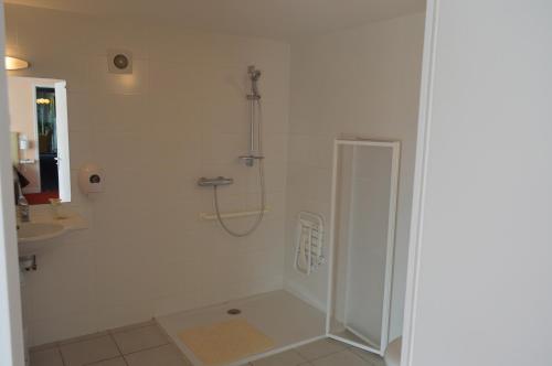 a white bathroom with a shower and a sink at Logis Hôtel Le Bretagne in Le Vivier-sur-Mer