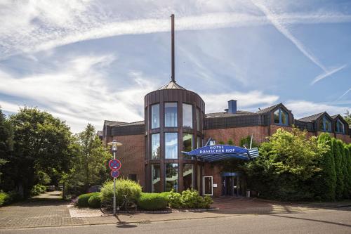 a building with a sign on the front of it at Hotel Dänischer Hof Altenholz by Tulip Inn in Altenholz