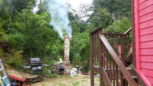 a chimney with smoke coming out of it next to a house at Heidi Korea in Hongcheon