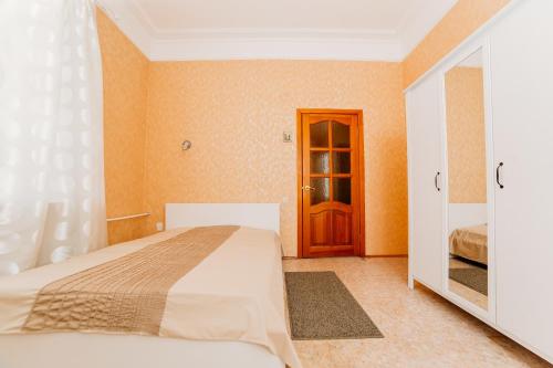 um quarto com uma cama, um espelho e uma porta em Apartment Peshekhodnaya ul. Baumana em Kazan