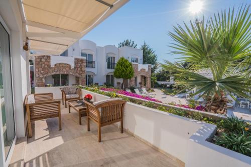 eine Terrasse mit Stühlen und einem Tisch auf dem Balkon in der Unterkunft Costa Sariyaz Hotel Bodrum in Bodrum City