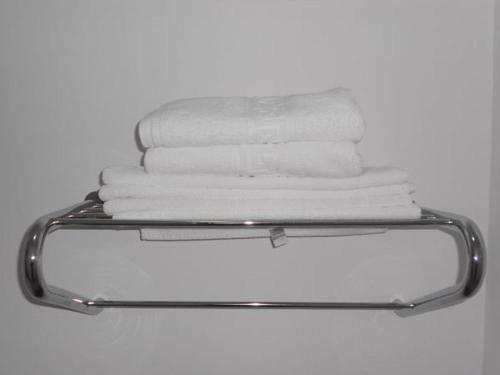a stack of towels on a towel rack in a bathroom at Hotel Tantzi in Sinaia