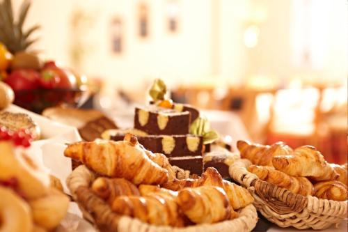 a table topped with different types of bread and pastries at Hotel Dänischer Hof Altenholz by Tulip Inn in Altenholz