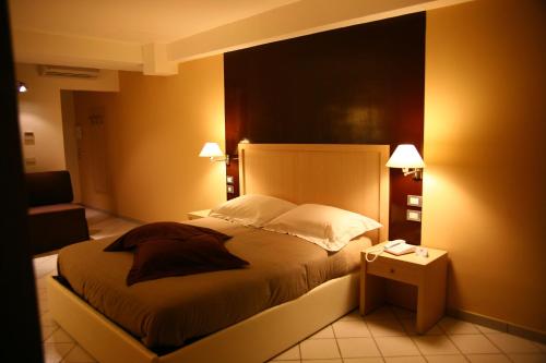 a bedroom with a bed and a chair and lights at De Maria House in SantʼAgata sui Due Golfi
