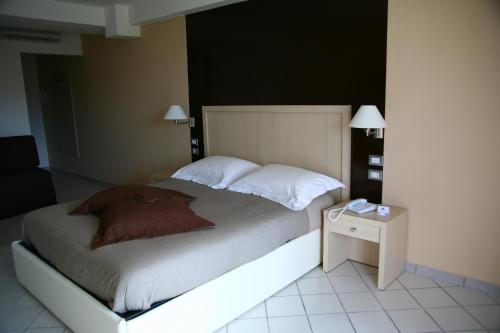 a bedroom with a bed with a nightstand and a bed sidx sidx at De Maria House in SantʼAgata sui Due Golfi
