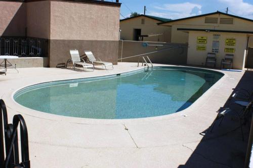 a large swimming pool with chairs and a building at HWY Express Inn and Suites in Thatcher