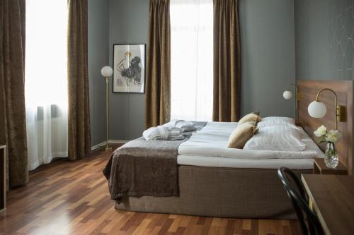 a bedroom with a bed and a desk and a window at Hotell Boras, BW Signature Collection in Borås