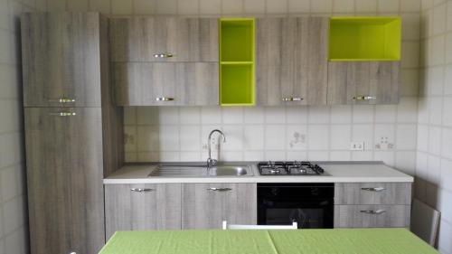 a kitchen with wooden cabinets and a sink and a stove at Estia in Salemi
