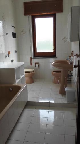 a bathroom with a sink and a toilet and a window at Estia in Salemi