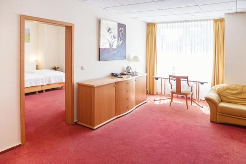 a room with a bed and a desk and a chair at Hotel Dänischer Hof Altenholz by Tulip Inn in Altenholz