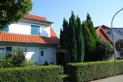 a white house with an orange roof and bushes at Lilo Luisa in Weinheim